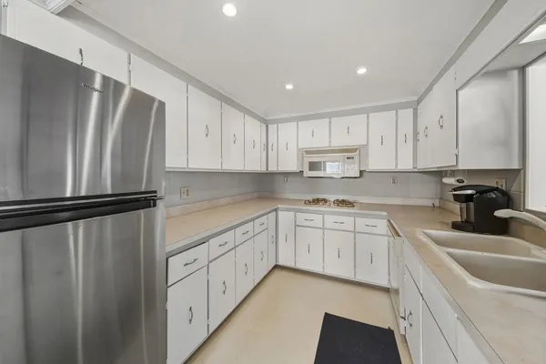 a kitchen with white cabinets sink and stainless steel appliances
