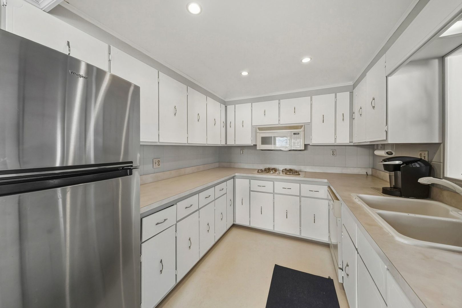 1515 North River Road McHenry, IL 60051 - Photo 21 of 27 a kitchen with white cabinets sink and stainless steel appliances