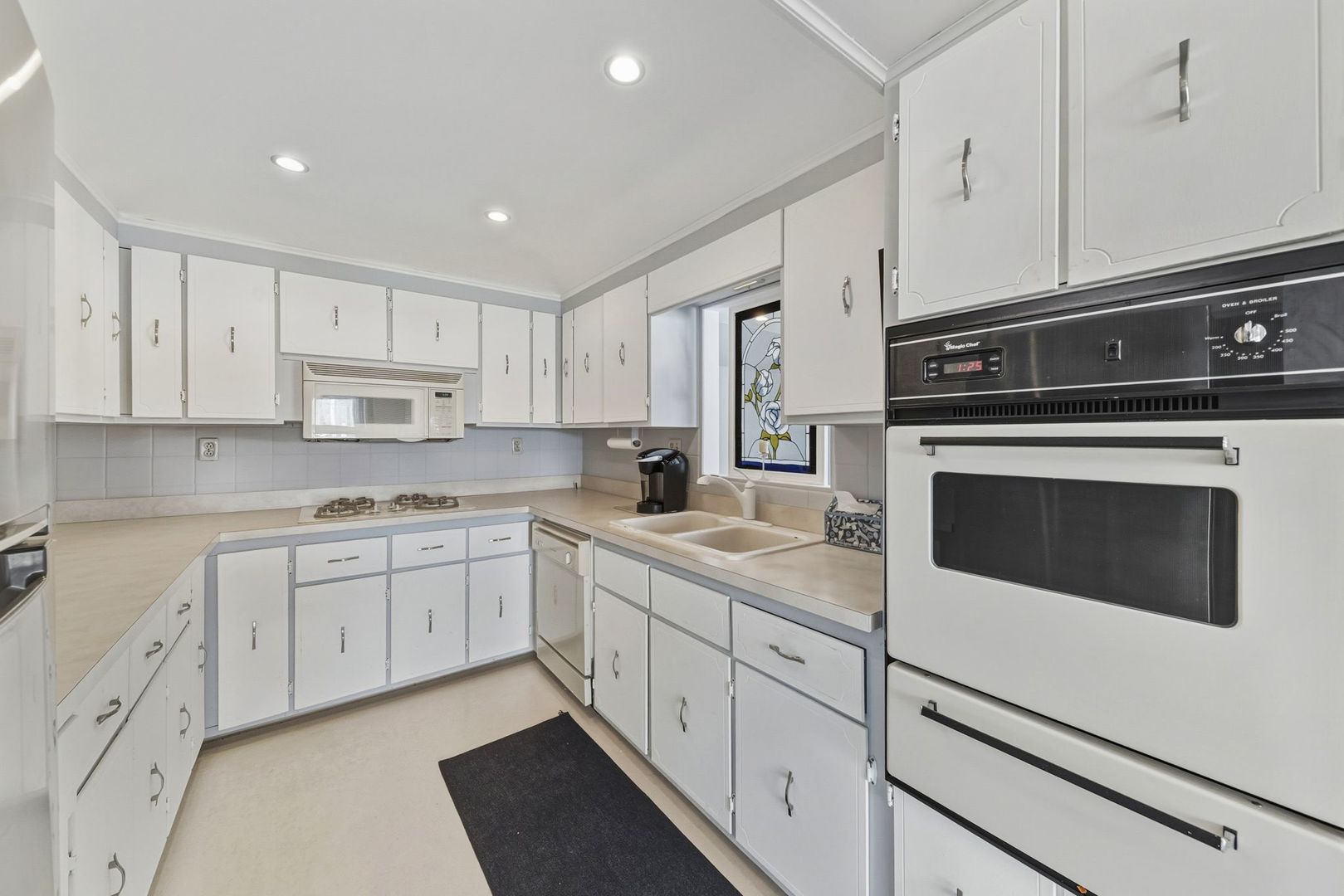 1515 North River Road McHenry, IL 60051 - Photo 22 of 27 a kitchen with a sink stove and cabinets