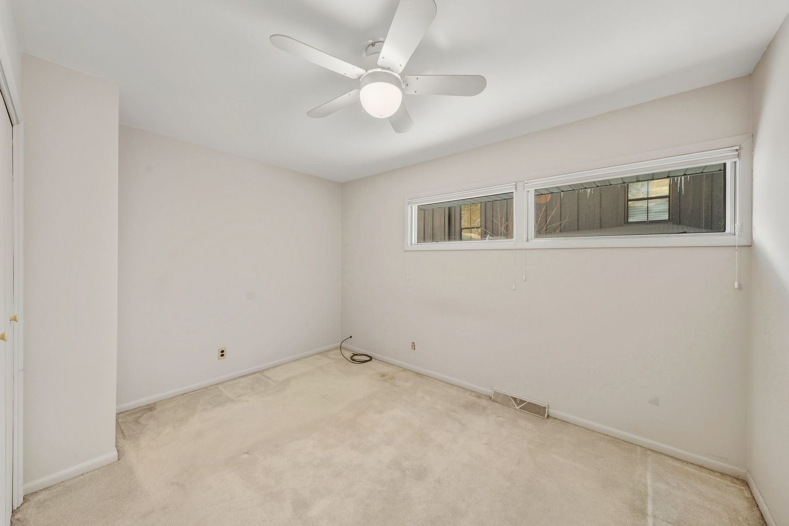 1515 North River Road McHenry, IL 60051 - Photo 24 of 27 an empty room with a ceiling fan and window