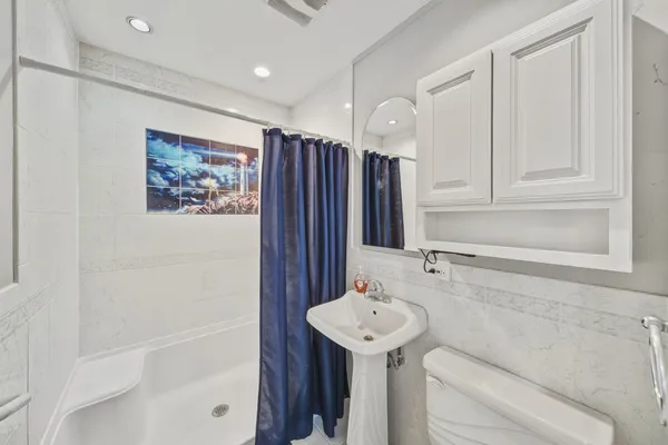 a bathroom with a sink a toilet and shower