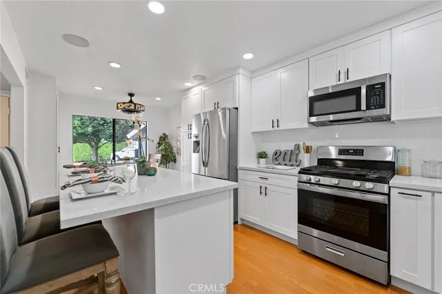 a kitchen with stainless steel appliances a stove microwave and refrigerator