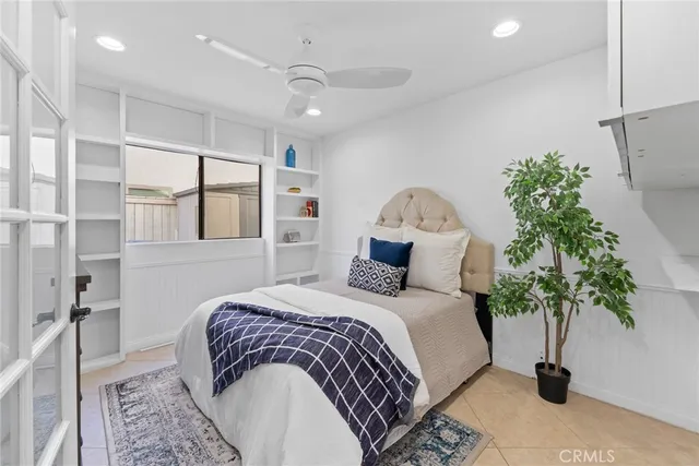 a bedroom with a large bed and a potted plant