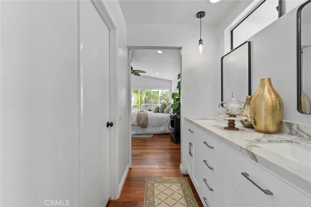 a en suite bathroom with a granite countertop sink and mirror