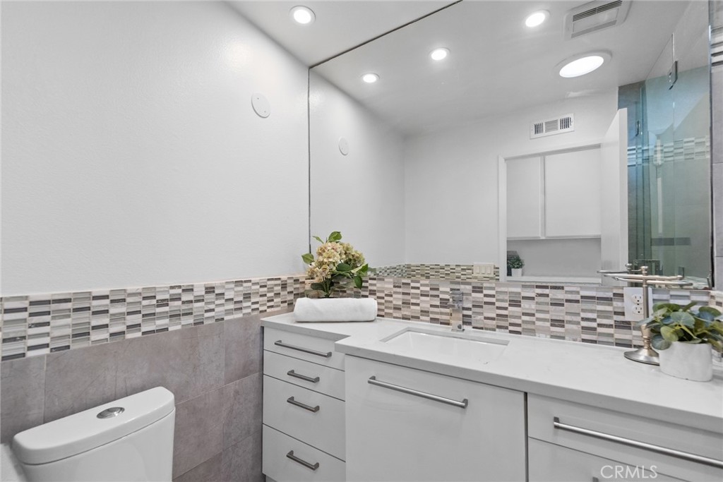 7 Boone Irvine, CA 92620 - Photo 31 of 38 a bathroom with a granite countertop sink and a mirror