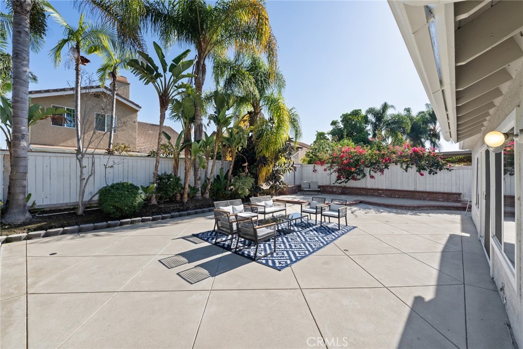 7 Boone Irvine, CA 92620 - Photo 35 of 38 a view of a patio with dining table and chairs with potted plants and big trees