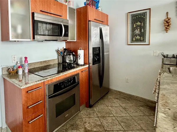 a kitchen with stainless steel appliances granite countertop a refrigerator and a stove