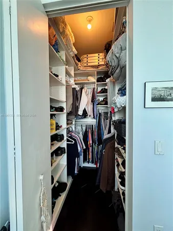 a view of walk in closet with clothes and shoes