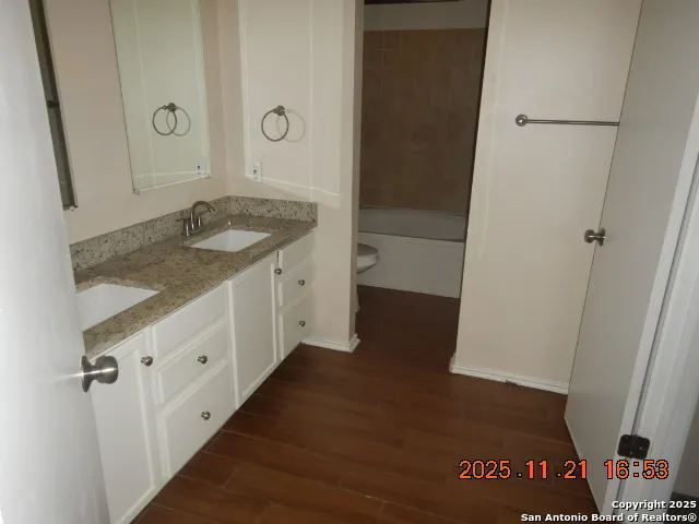 a bathroom with a granite countertop sink and a mirror