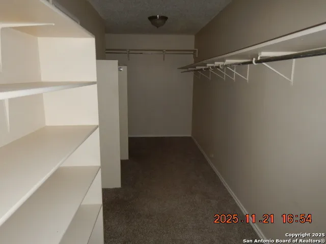 a view of walk in closet with empty racks