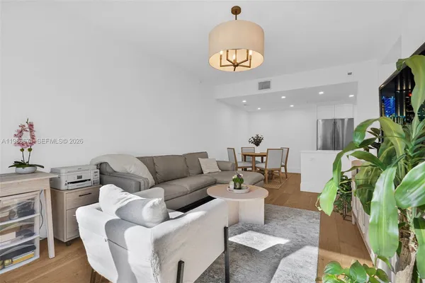 a living room with furniture a chandelier and a dining table