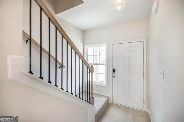 a view of a hallway with wooden floor and staircase