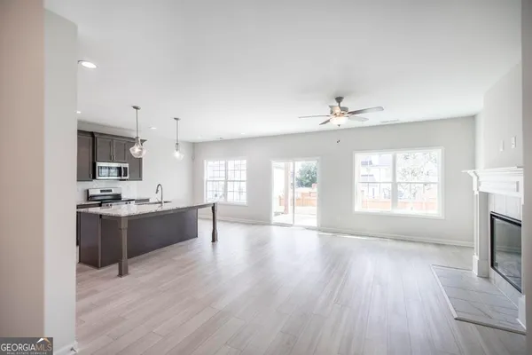 a large kitchen with cabinets wooden floor and stainless steel appliances