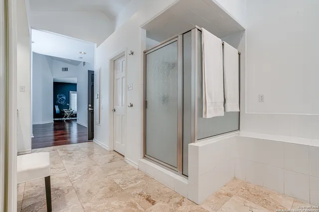 a view of a hallway with closet and a bathroom