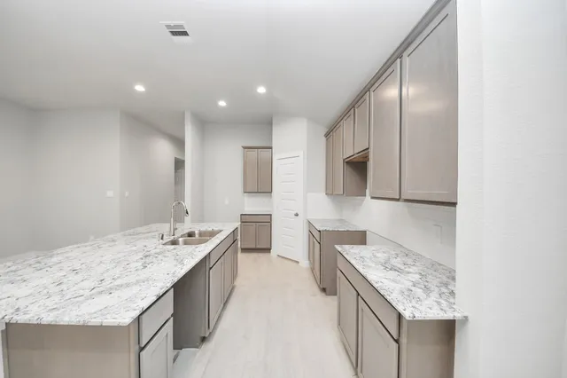 a view of kitchen with sink cabinets and window