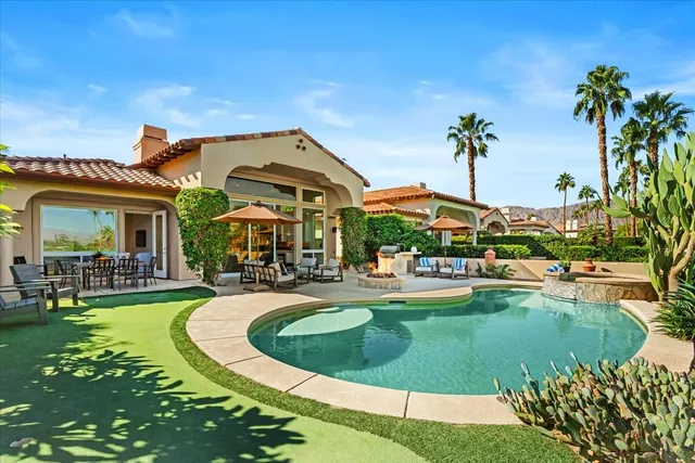 a view of a house with swimming pool and sitting area