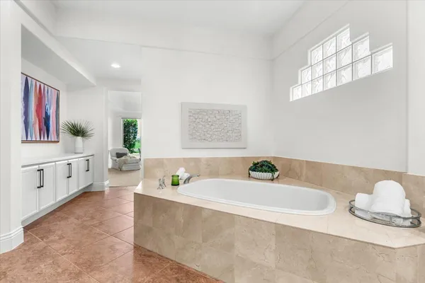 a bathroom with a tub sink and mirror
