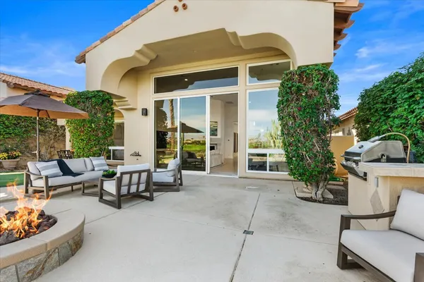 a view of a patio with couches table and chairs and potted plants