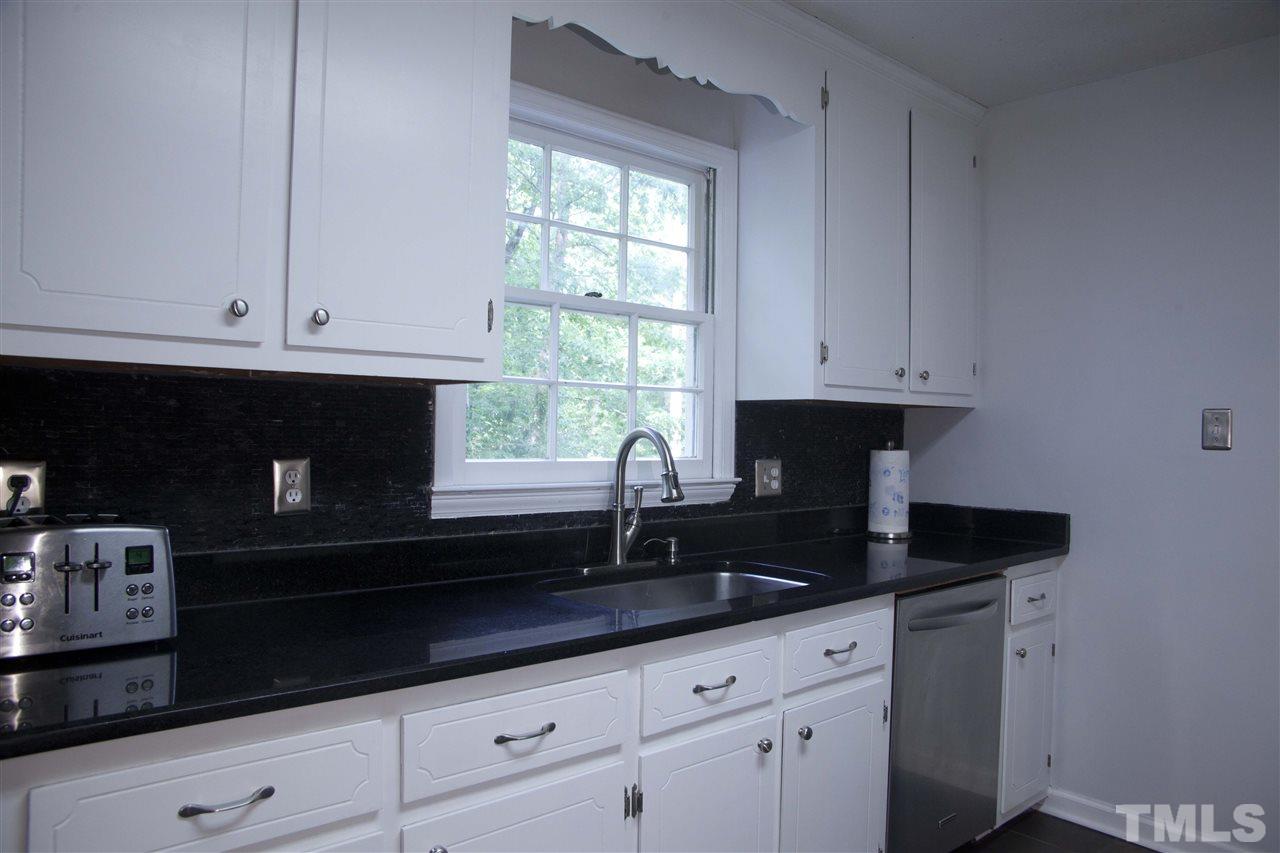 707 Torredge Road Durham, NC 27712 - Photo 6 of 21 a kitchen with granite countertop white cabinets sink and a granite counter top