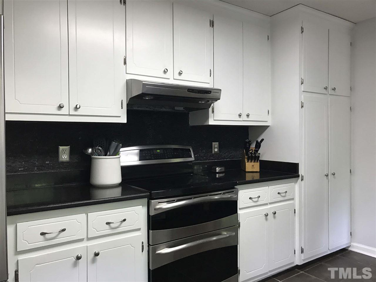 707 Torredge Road Durham, NC 27712 - Photo 7 of 21 a kitchen with white cabinets and appliances