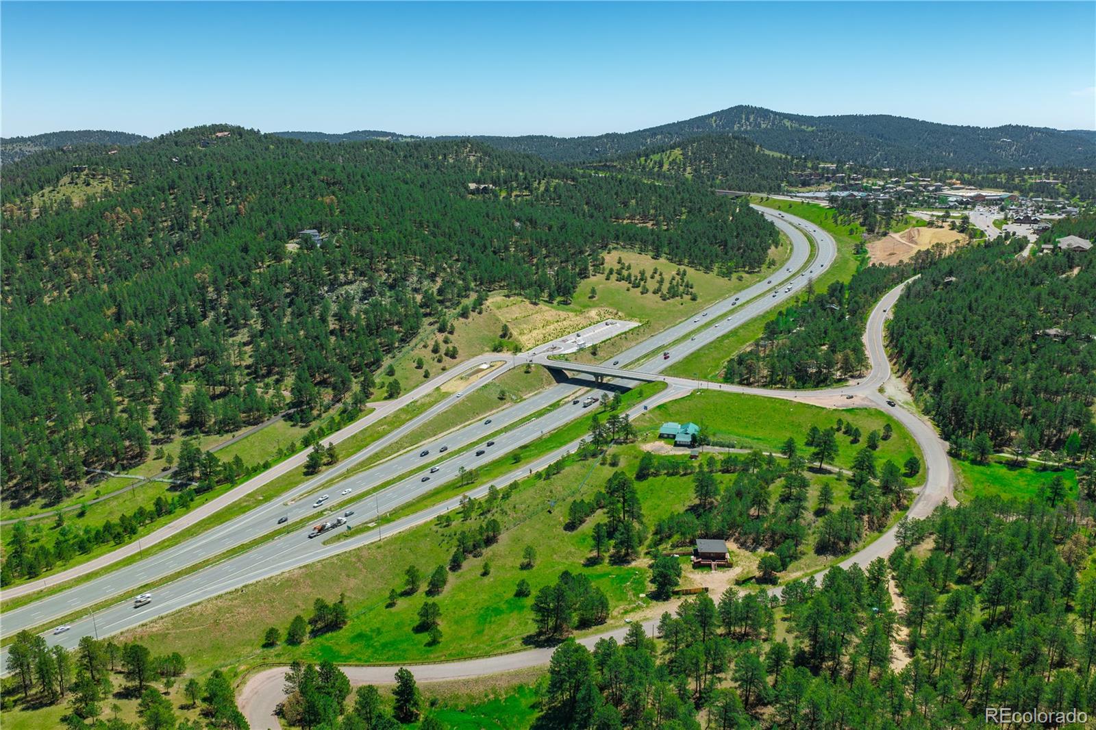 29793 Ruby Ranch Road Evergreen, CO 80439 - Photo 2 of 28 a view of a lush green field with a view of mountains in the background