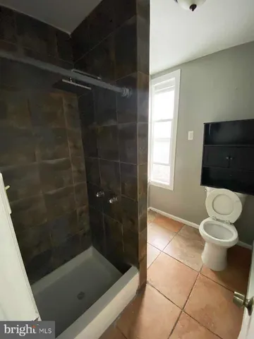 a bathroom with a toilet and a shower