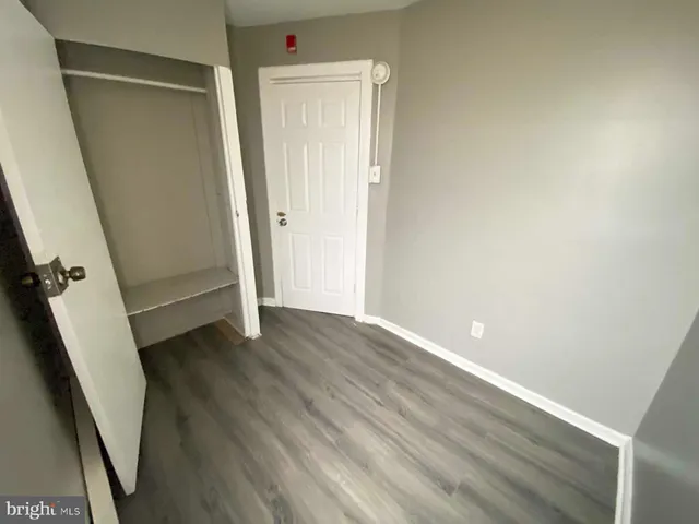 an empty room with wooden floor and closet
