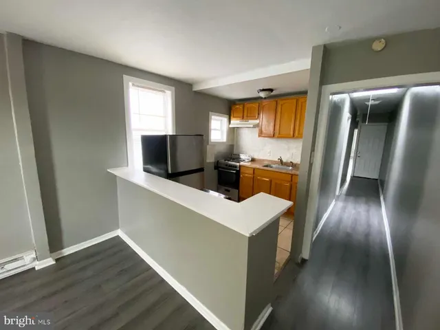 a kitchen with stainless steel appliances a refrigerator and wooden floor