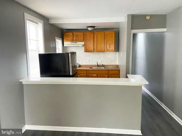 a view of a kitchen with a sink and a refrigerator