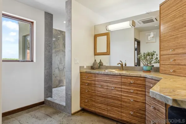 a bathroom with a granite countertop bathtub and shower