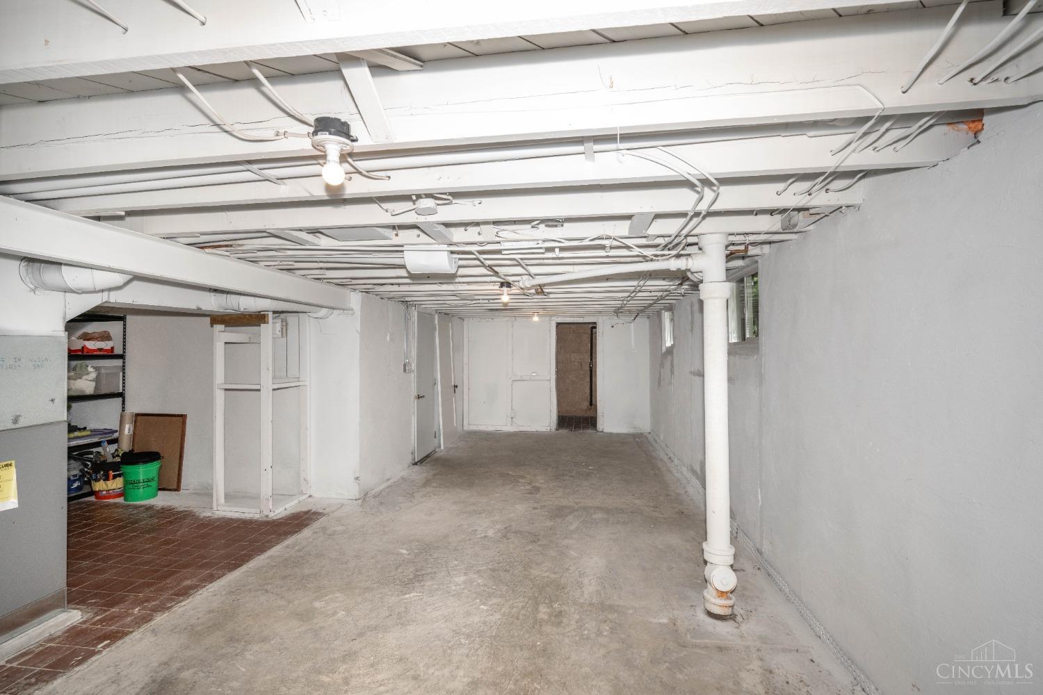 7396 Dawson Road Madeira, OH 45243 - Photo 29 of 42 View of the unfinished Basement from the back toward the front of the home! There's an additional storage area through the open door!