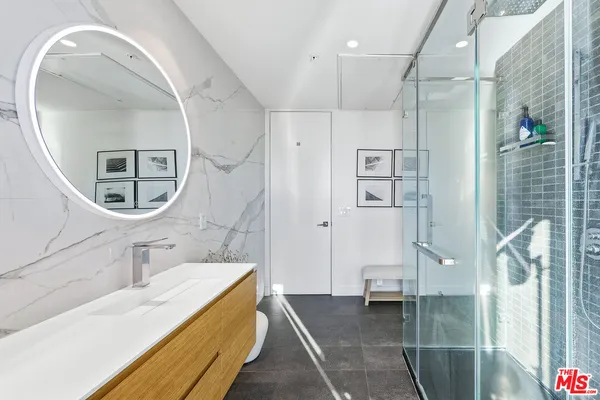 a spacious bathroom with a granite countertop sink a mirror a bathtub and shower