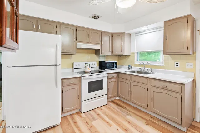 a kitchen with a sink cabinets and window