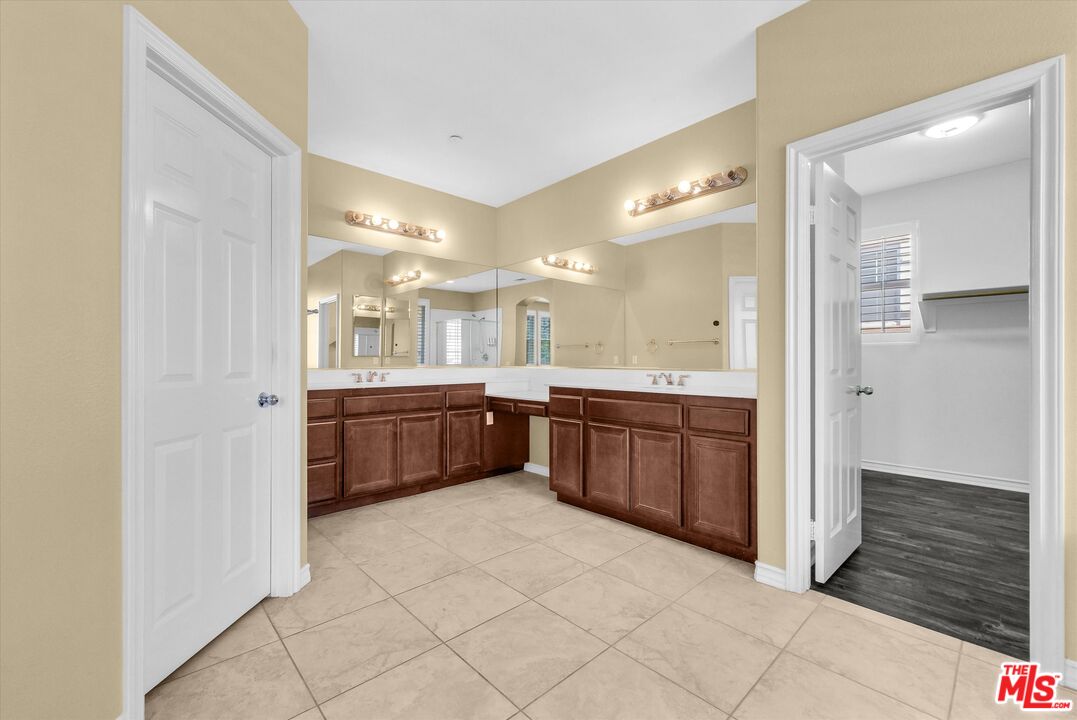 5611 Scharf Avenue Fontana, CA 92336 - Photo 25 of 49 a large bathroom with a large mirror vanity and a sink