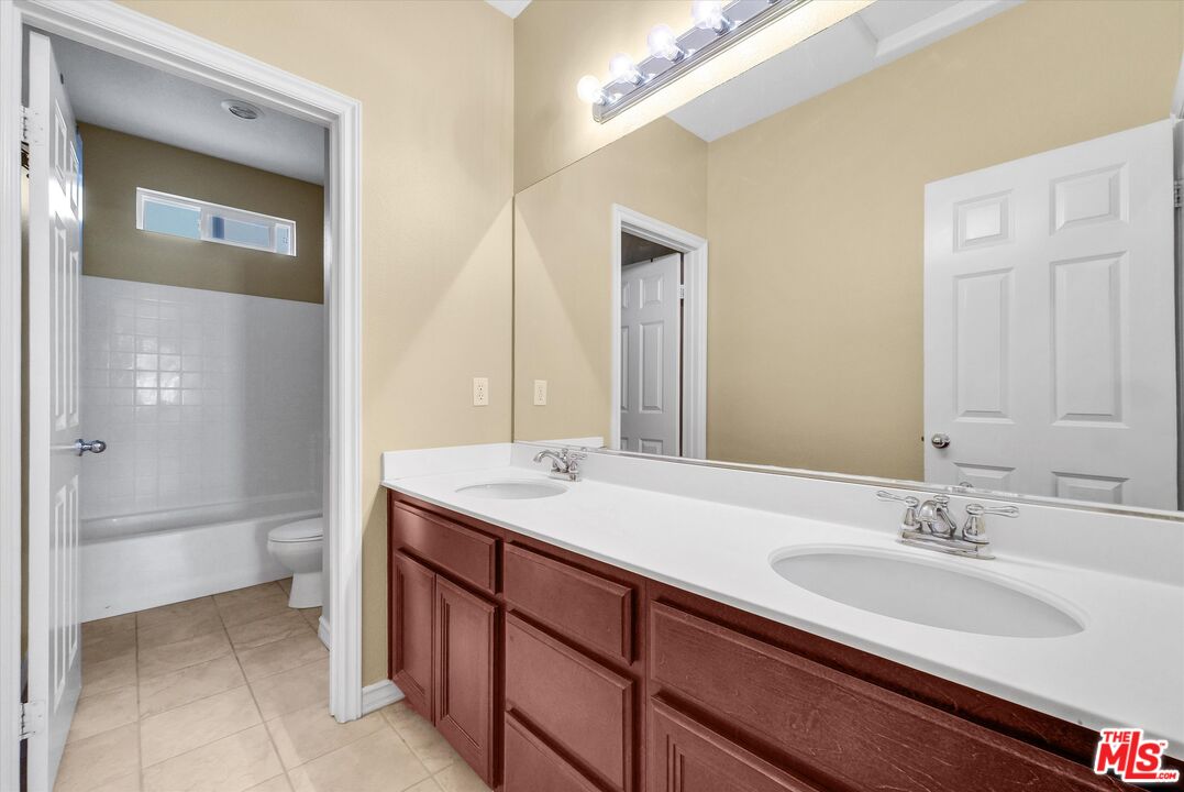 5611 Scharf Avenue Fontana, CA 92336 - Photo 29 of 49 a bathroom with a sink double vanity and a mirror