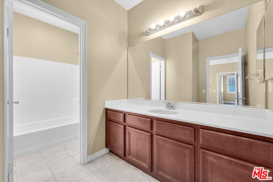 5611 Scharf Avenue Fontana, CA 92336 - Photo 34 of 49 a bathroom with a tub a sink and a mirror