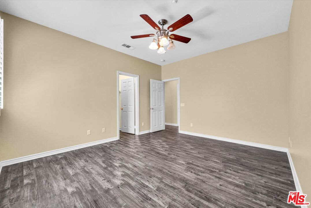 5611 Scharf Avenue Fontana, CA 92336 - Photo 36 of 49 an empty room with wooden floor and ceiling fan