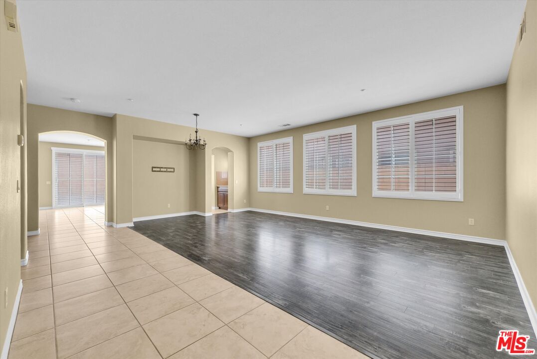 5611 Scharf Avenue Fontana, CA 92336 - Photo 6 of 49 a view of an empty room with glass door and wooden floor