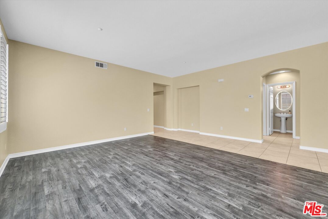 5611 Scharf Avenue Fontana, CA 92336 - Photo 7 of 49 a view of an empty room with wooden floor and a window