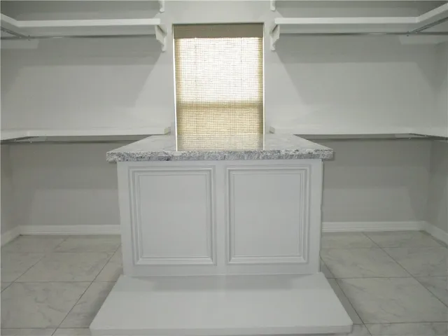 a bathroom with a granite countertop sink and a window
