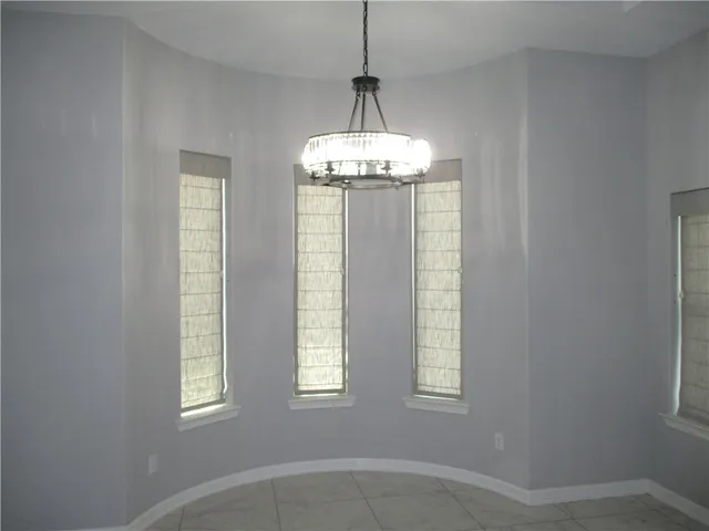 an empty room with windows and chandelier