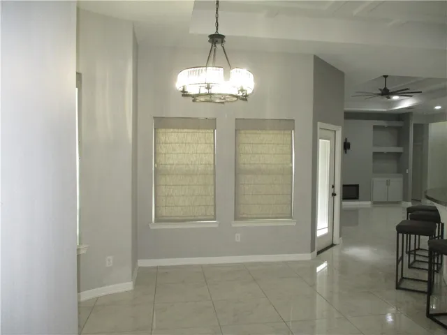a view of a livingroom with a chandelier a livingroom and windows