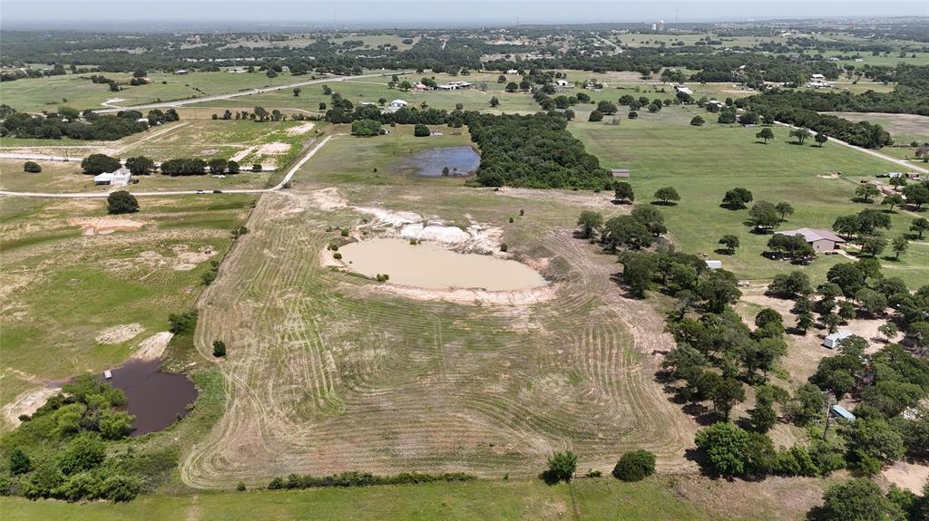 8605 West Highway 199 Springtown, TX 76082 - Photo 7 of 23 Expansive rural landscape featuring multiple ponds, scattered mature trees, and a clear dirt road