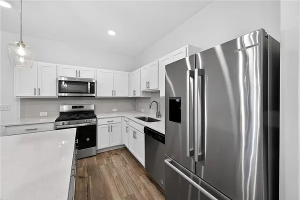 a kitchen with stainless steel appliances granite countertop a refrigerator stove and sink