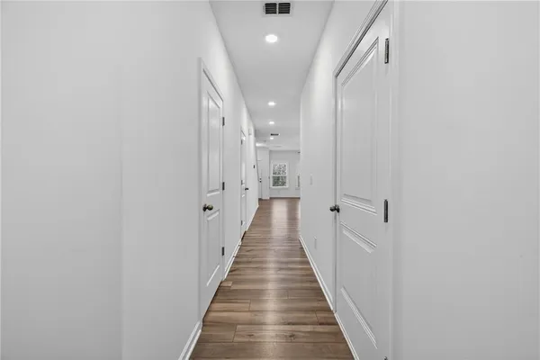 a view of a hallway with wooden floor and staircase