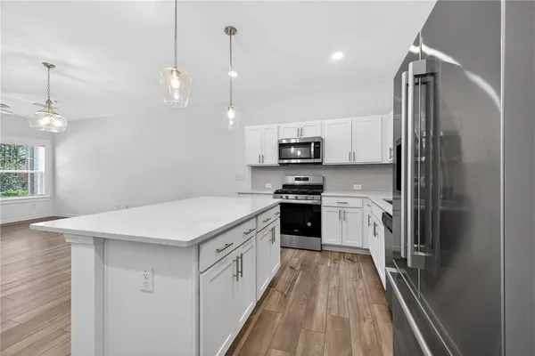 a kitchen with kitchen island a sink appliances and cabinets