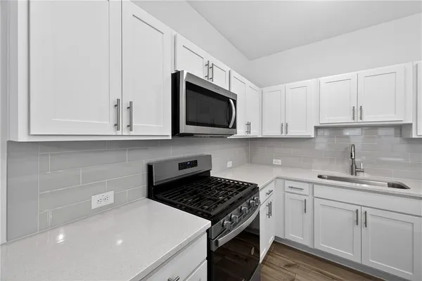 a kitchen with stainless steel appliances granite countertop white cabinets a sink and dishwasher