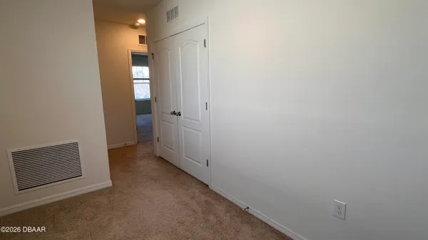 a view of a hallway with wooden floor and a bathroom