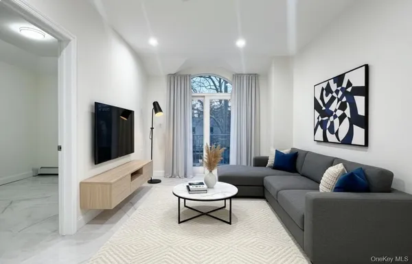 a kitchen with stainless steel appliances kitchen island granite countertop a dining table chairs and a refrigerator