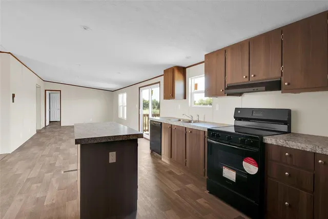 a kitchen with granite countertop a sink stove and cabinets